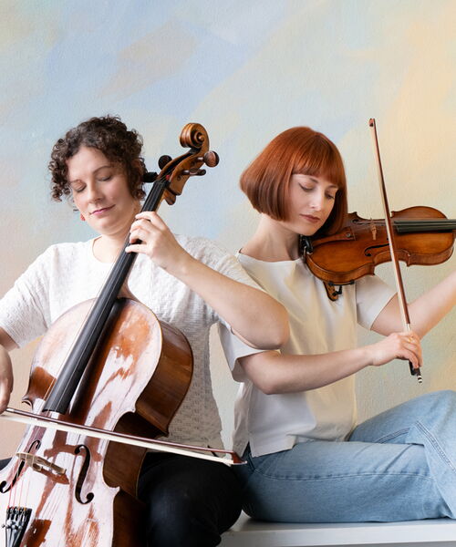 Zu sehen sind die beiden Musikerinnen mit ihren Streichinstrumenten.