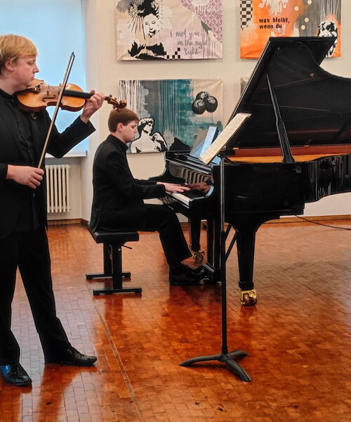 Zu sehen sind Alexander und Eduard Sonderegger am Klavier und an der Geige