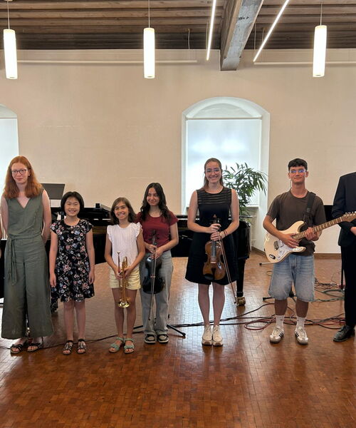 Zu sehen sind die Beteiligten des Konzerts mit einem Instrument in der Hand haltend
