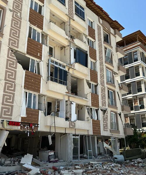 Zu sehen ist ein Hochhaus, dass durch die Erdbeben in der Türkei zerstört worden ist