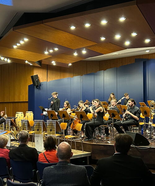 Zu sehen sind die Musikerinnen und Musiker auf der Bühne des Hans-Baldung-Grien-Saals