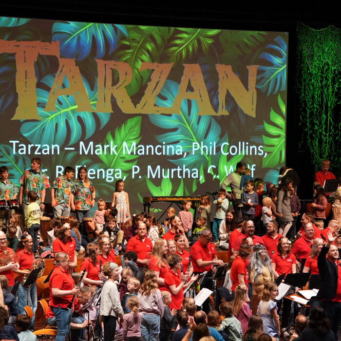 Zu sehen sind Musikerinnen und Musiker des Kinderkonzertes sowie die Kinder die selbst mal Instrumente ausprobieren.