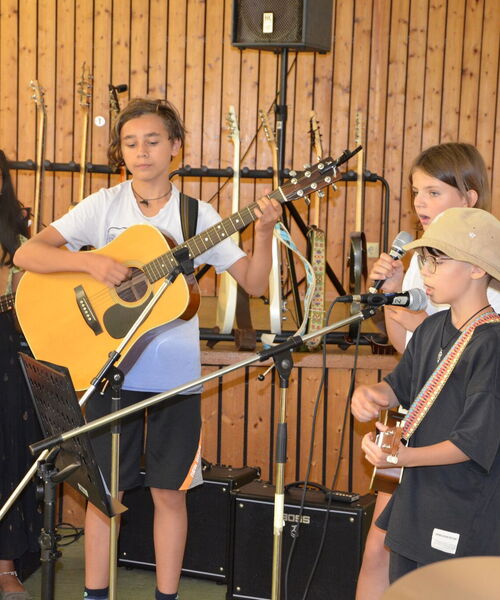 Kinder mit verschiedenen Instrumenten musizieren gemeinsam.
