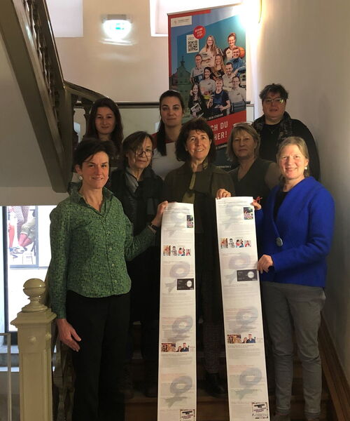 Zu sehen sind die Veranstalterinnen mit der Programmübersicht.