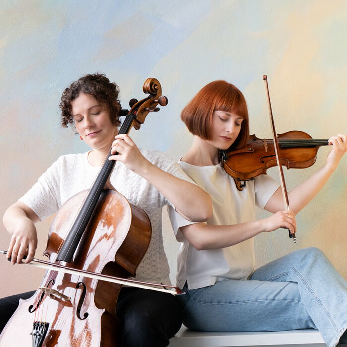 Zu sehen sind die beiden Musikerinnen mit ihren Streichinstrumenten.