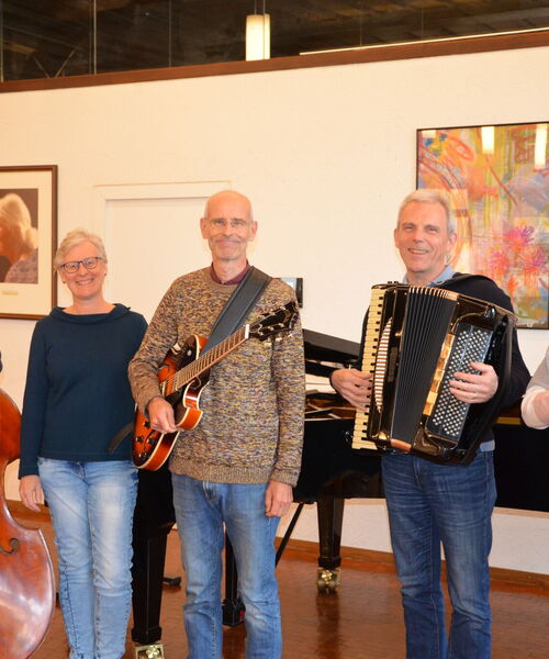 Eine Gruppe von Menschen mit Kontrabass, Gitarre, Akkordeon und Geige.